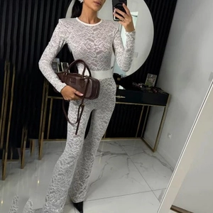 Close-up of white lace jumpsuit with long sleeves and elegant flared leg design