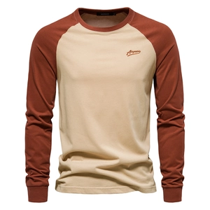 Close-up of contrast rib-knit neckline and brand embroidery on raglan long sleeve shirt