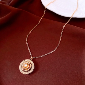 Vintage gold rose pendant necklace with zircon flower and shimmering crystals on fabric