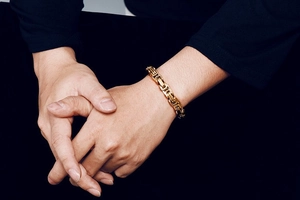 Close-up of golden Byzantine chain bracelet for men with intricate woven metal texture
