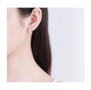 Close-up of S925 silver hoop earring with five white pearls worn on a model's ear