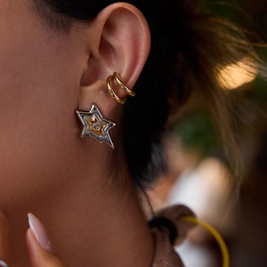 Gros plan de boucles d'oreilles étoile avec cristal et manchette d'oreille dorée sur un modèle