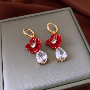 18k gold plated earrings featuring red enamel flowers and pear-shaped crystals on box
