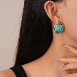 Gros plan de boucles d'oreilles vintage turquoise carrées avec strass sur modèle