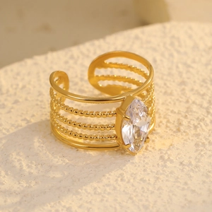 Detailed macro of gold-plated multi-row ring featuring a marquise-cut clear gemstone