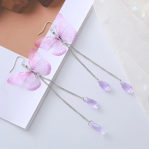 Vue détaillée de boucles d'oreilles papillon avec longs glands et pendentifs violets