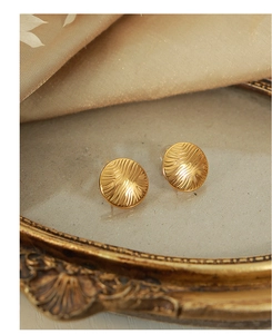 Detailed view of golden round titanium steel earrings with unique water ripple texture