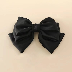 Detail view of smooth black satin bow hair clip with double-layer design and elegant finish