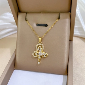 Detail of gold butterfly star pendant with clear crystals in a jewelry box