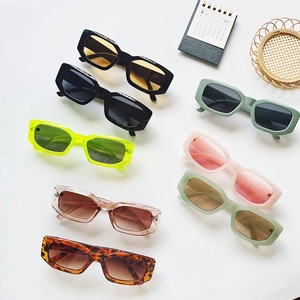 Flat lay of retro rectangle sunglasses in various colors including black and neon green