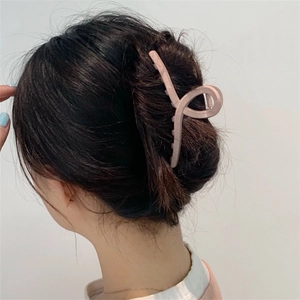 Detalle de una pinza para el pelo rosa pálido con diseño retorcido para peinados elegantes