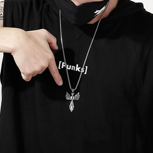 Detailed view of men's silver angel wing pendant necklace worn by model on black background