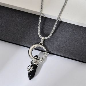 Detailed close-up of a silver crescent moon and star pendant with black hexagonal crystal