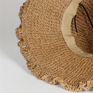 Detail view of woven straw hat featuring a wavy brim edge and adjustable inner sweatband