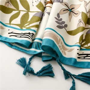 Close-up of floral satin shawl featuring intricate teal tassels and botanical prints