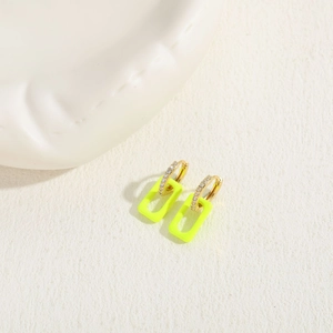 Macro detail of neon yellow geometric earrings with gold-plated zircon inlay hoops