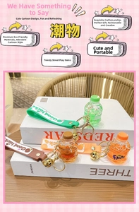 Detail of creative mini soda bottle keychain with Good Luck strap and gold bell