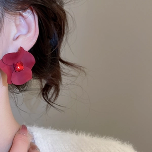 Close-up of a large vintage red flower stud earring with a square crystal centerpiece