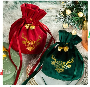 Close-up of velvet Christmas pouches with golden bells and festive reindeer patterns
