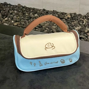 Sky blue and cream makeup bag with brown handles featuring a cute cartoon illustration