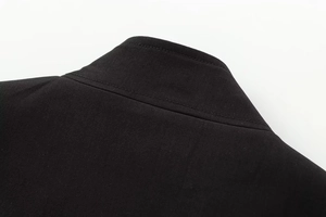 Detailed close-up of the black twill fabric and stand-up collar stitching on the jacket