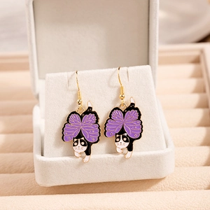 Detail view of cartoon black and white cat earrings with purple butterfly wings
