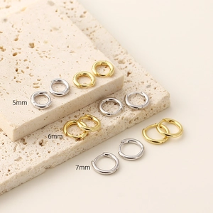 Macro shot of 925 sterling silver hoop earrings in gold and silver with size labels