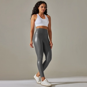 Detailed texture of high-waist faux leather leggings with matte finish and white tank top