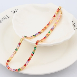 Vue détaillée d'un collier arc-en-ciel doré avec zircons carrés colorés sur une assiette coquille