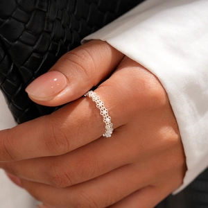 Close-up of woman's hand wearing silver lace hollow ring with delicate micro pearls
