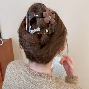 Brown tortoise shell hair claw clip with plush bear and rhinestone bow on long wavy hair