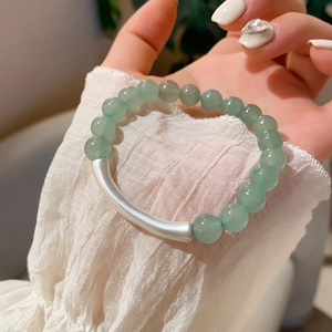 Detail of green aventurine beaded bracelet with a matte silver curved metal tube