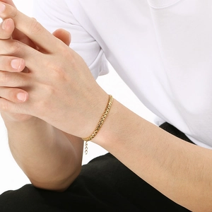 Détail d'un bracelet tressé doré ajustable avec chaîne d'extension sur poignet masculin