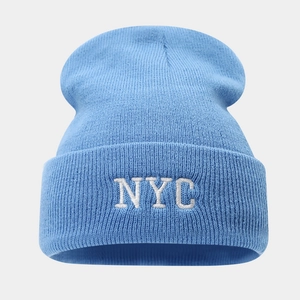Détail d'un bonnet tricoté bleu clair avec broderie NYC blanche et texture côtelée