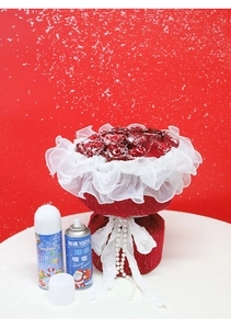 Close-up of a festive red rose bouquet with pearl beads and two cans of artificial snow spray