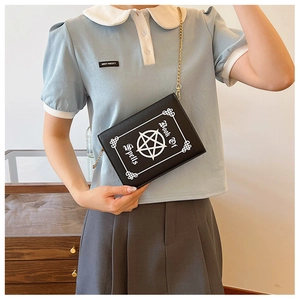 Detail of gothic Book of Spells crossbody bag featuring a star print and gold chain strap