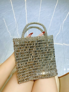 Detailed view of handmade silver beaded handbag with a shiny metallic weave texture