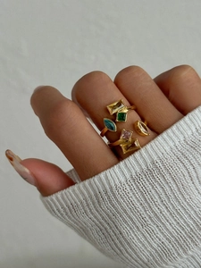 Close-up of gold-plated rings featuring colorful geometric zircons in a stacked style