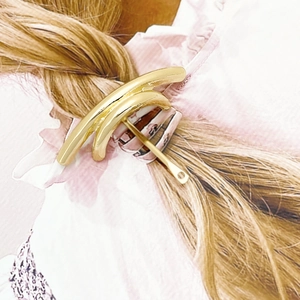 Close-up of minimalist golden U-shaped hair hook clip on low ponytail hairstyle