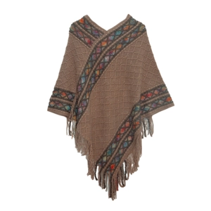 Detail of brown knitted poncho with colorful geometric patterns and decorative tassels
