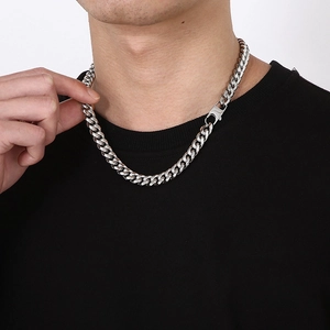 Detail of chunky silver stainless steel Cuban chain necklace worn by a model
