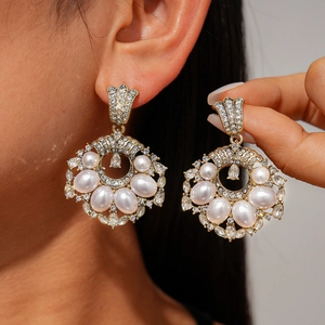 Elegant vintage gold drop earrings with pearls and rhinestones on female model