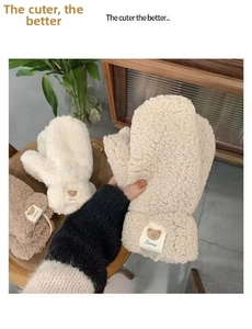 Detail of warm lamb wool mittens with cute bear patch and elastic ribbed cuffs