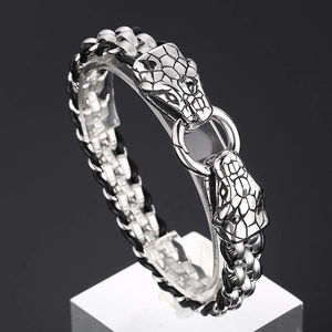 Detail of silver wolf head buckle on braided steel bracelet with professional black background