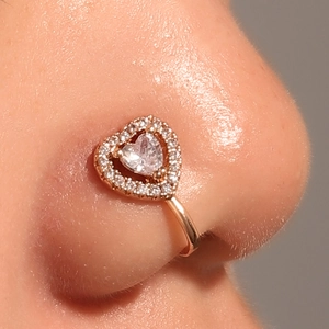 Macro detail of rose gold U-shaped non-pierced nose clip with heart cubic zirconia