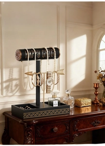 Macro detail of luxury double-layer jewelry stand with black cylinders and gold accents