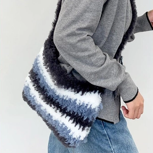 Detail of grey and blue striped plush crossbody bag with soft texture and winter style