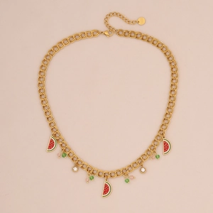Detailed view of watermelon and rhinestone pendants on a golden Cuban chain necklace