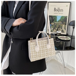 Detail of checkered tweed handbag in beige with leather handle and adjustable shoulder strap