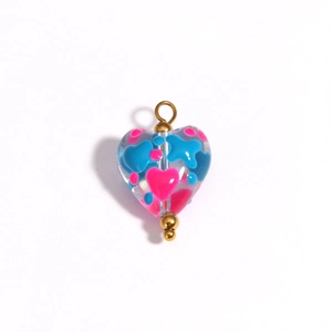 Detail of heart-shaped glass pendant with pink and blue patterns and gold hardware